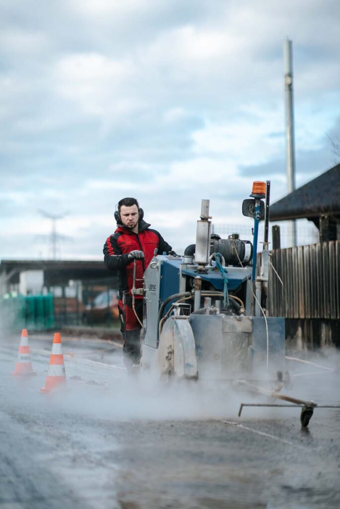 PHOTO D'UN PROFESSIONNEL DE L'ENTRPERISE STAMPER ENTRAIN DE RÉALSIER LE SCIAGE ÉBTON D'UNE ROUTE